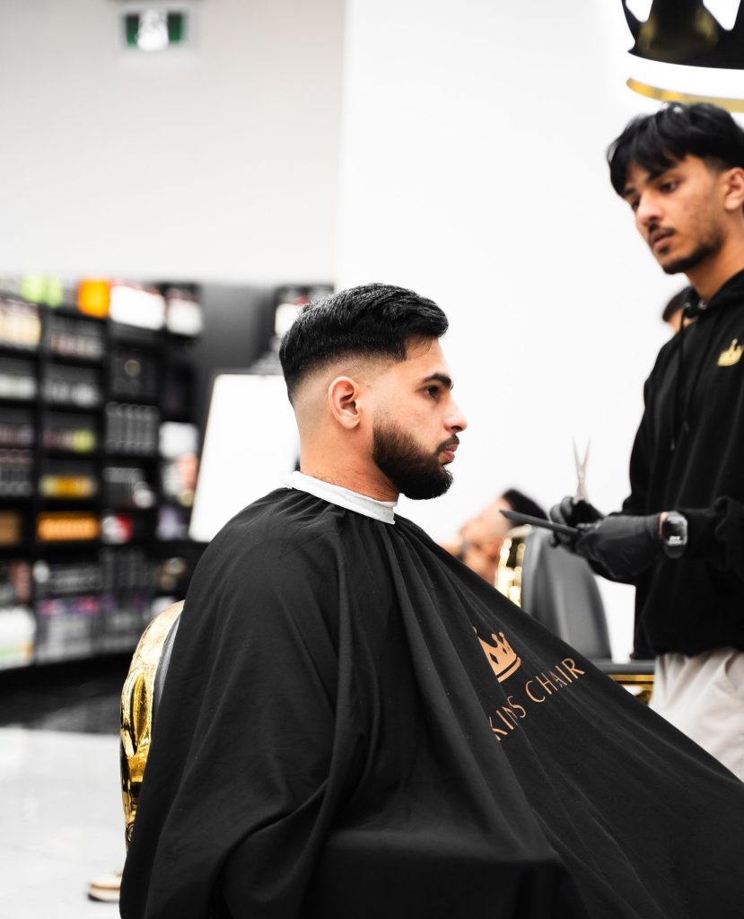 Primer plano de un corte de pelo con degradado de piel alta y parte superior texturizada – King's Chair Barbershop