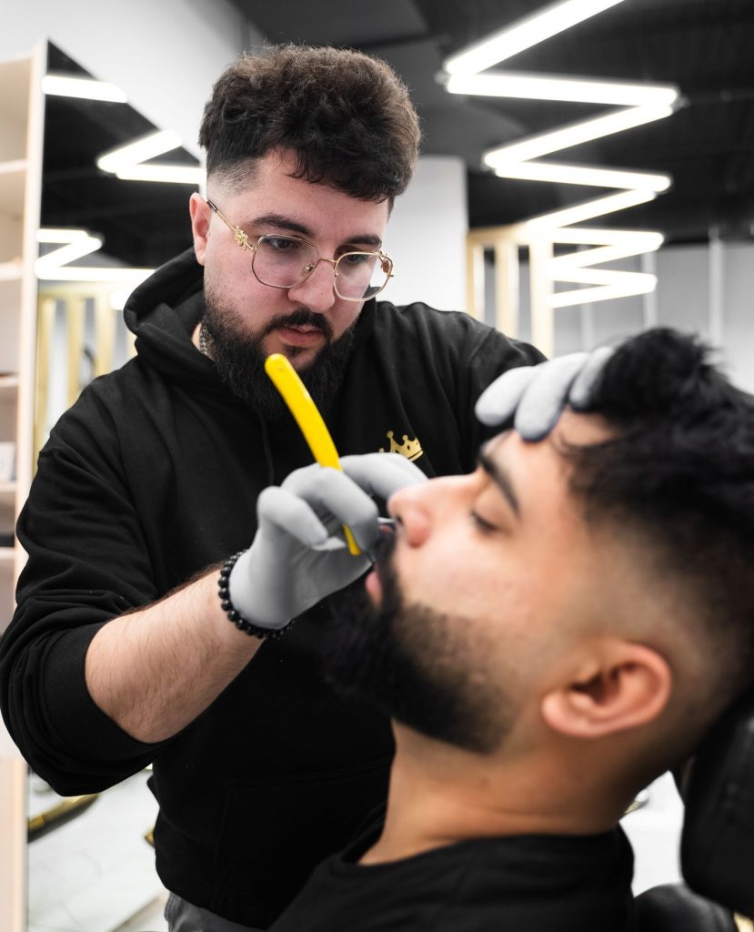 El mejor cuidado de barba en Mississauga y Vaughan: barbero profesional que da forma a la barba del cliente en King's Chair