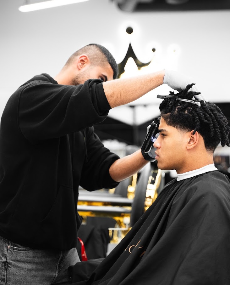 Gentleman getting a haircut at King's Chair Barbershop, Financial Drive location